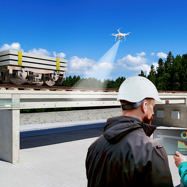 OpenLAB Bautzen: CARE research bridge for structural health monitoring and upgrading existing infrastructure. 2 Menschen mit einem Tablet vor einer Brücke auf der ein Wagen mit Gewichten auf Schienen entlang fährt während die Brücke von einer Drohne gescannt wird.